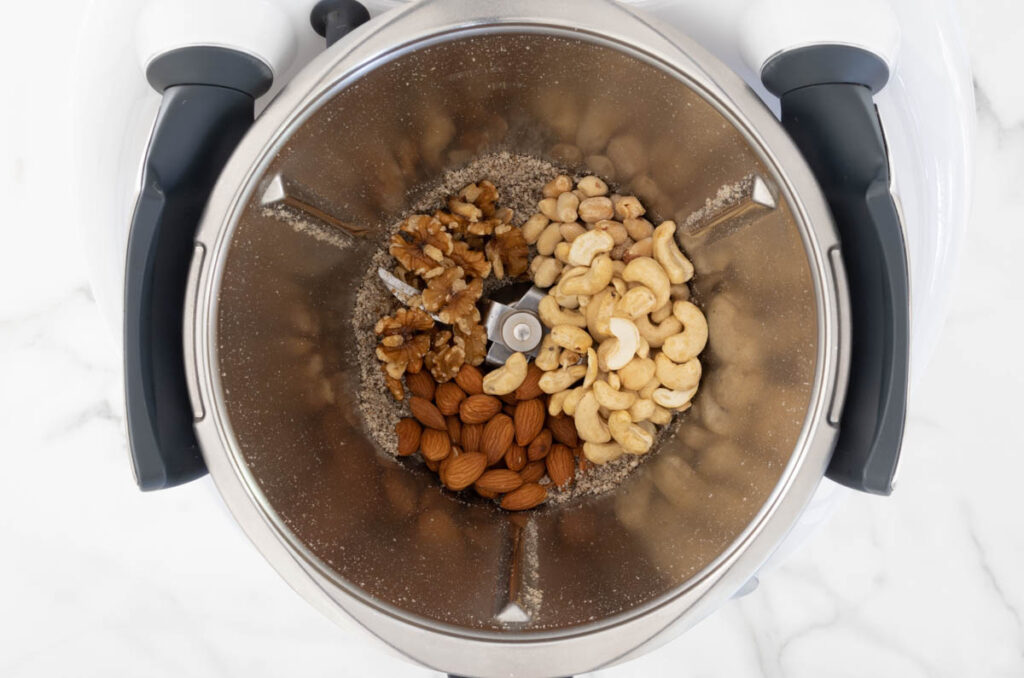 Step 2 of Nut and Seed Sprinkle process in a Thermomix, adding the almonds, walnuts, cashews and peanuts.