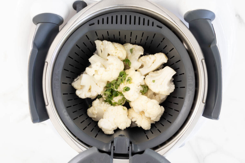 Step 1 of cauliflower puree process in a Thermomix, streaming the cauliflower and thyme.